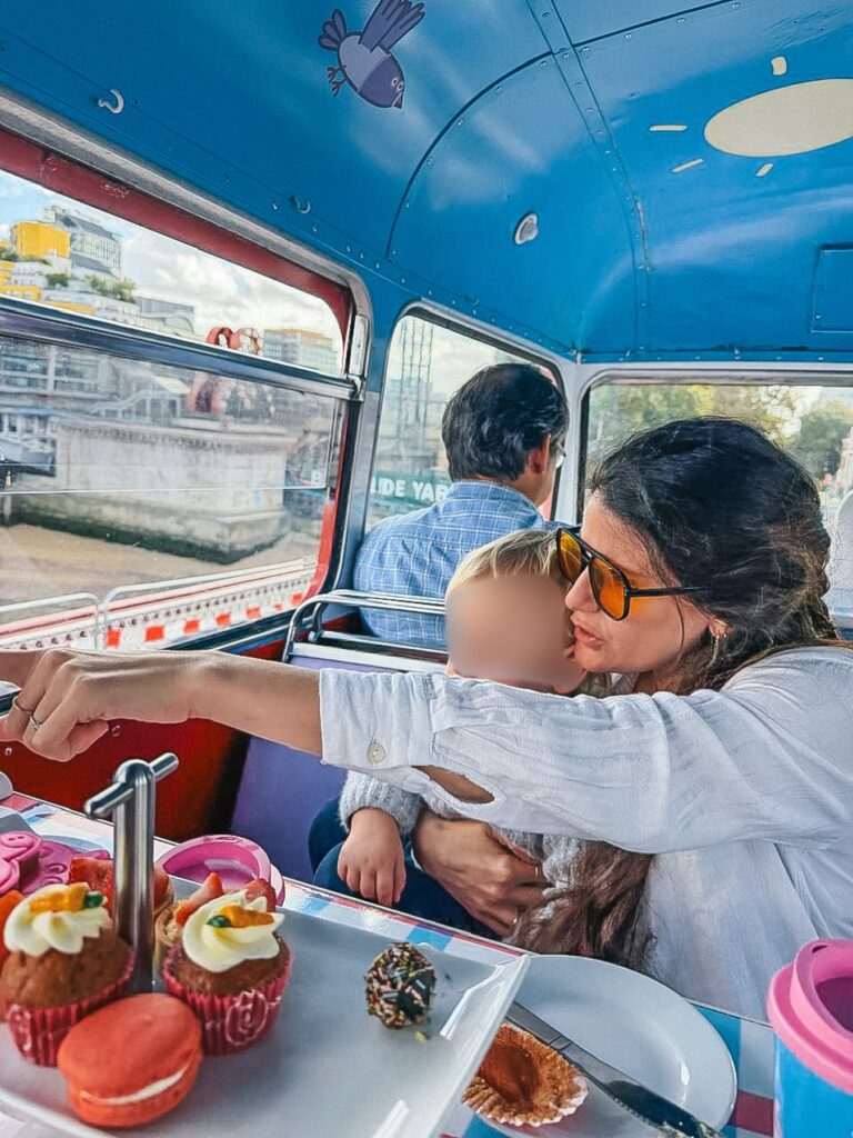 Inside the Peppa Pig bus tour in London, the blue decorated interior with a view of the River Thames