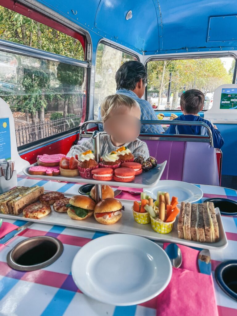 Peppa Pig afternoon tea stand with sandwiches, burger buns, veggie sticks and sweet treats on the bus tour