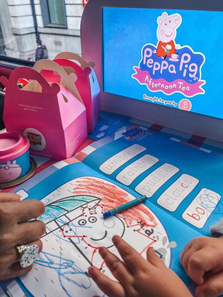 Peppa Pig afternoon tea bus tour activity book and pink takeaway box on the table