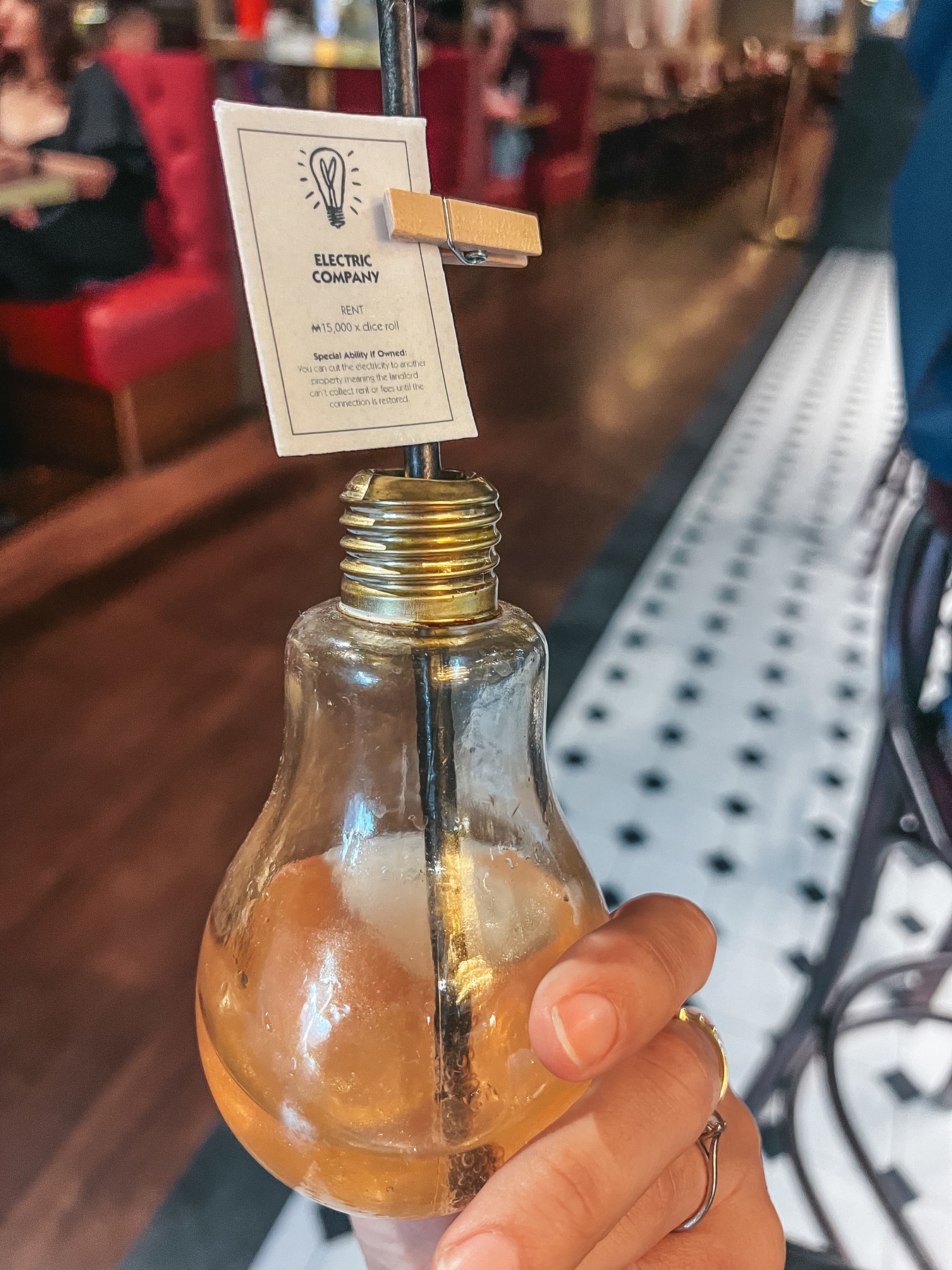 Electric Avenue cocktail served in a light bulb glass at the Top Hat Bar at Monopoly Lifesized London
