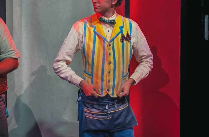 Monopoly Lifesized host in a striped waistcoat and straw boater hat standing at a table with a Monopoly board