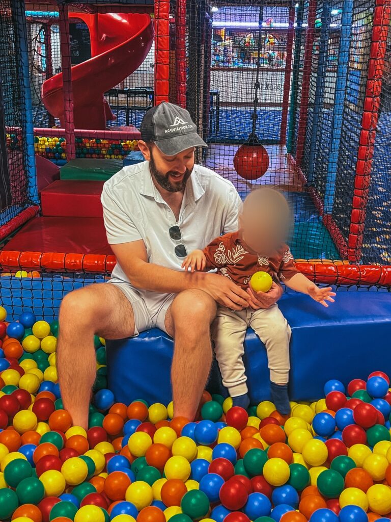 Dad and toddler sitting by the ball pit at Widget's World soft play in Margate